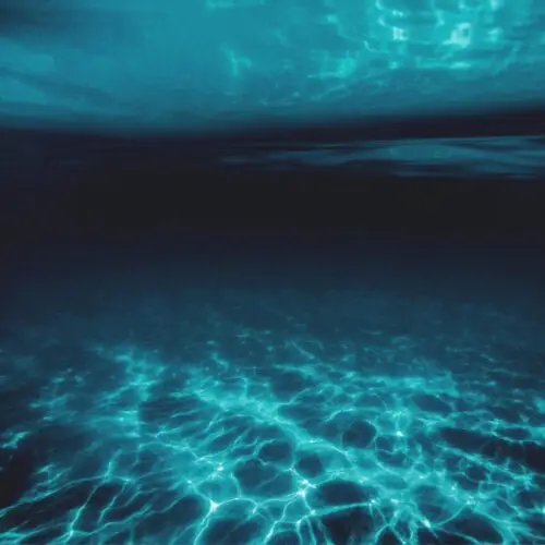 Deep blue underwater scene with captivating light and shadow play.